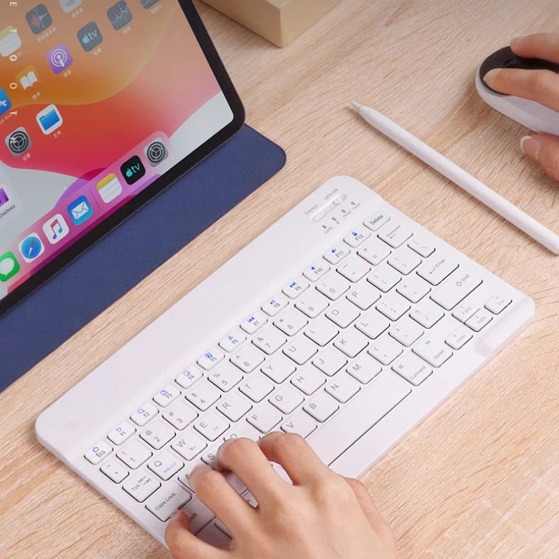 User typing on a white Bluetooth keyboard for iPad 2024, featured with a tablet and mouse, by Orbit Gear.