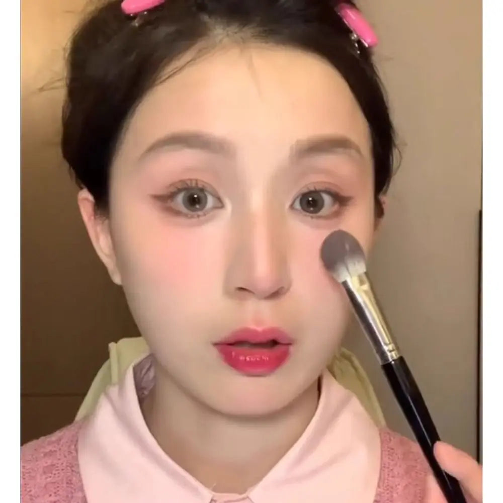 Portable 17CM Peach Heart Blusher Brush lies flat, emphasizing its unique tongue-shaped makeup tool design.