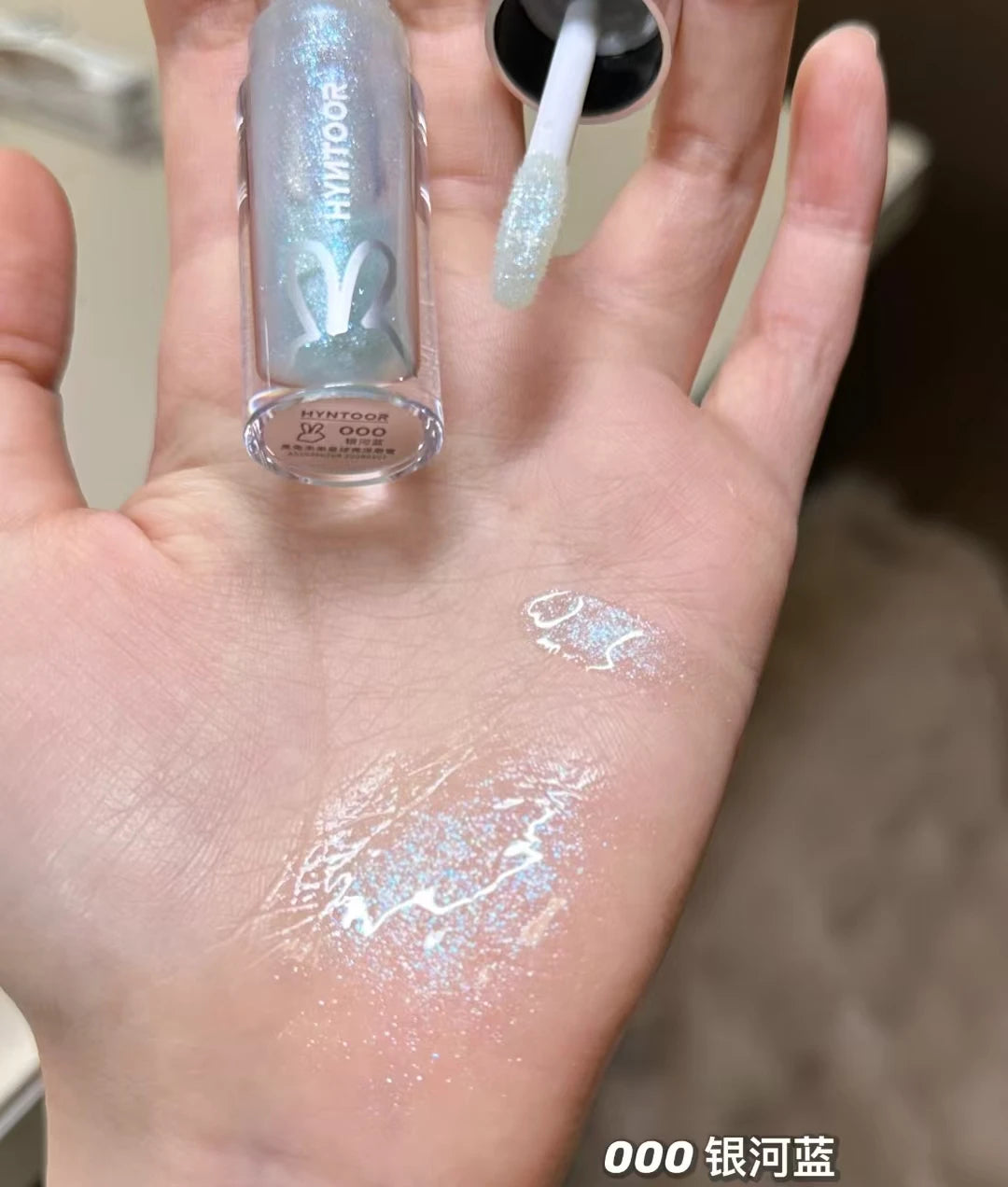 Model applying HYNTOOR Lip Gloss, the ideal shiny lip gloss for dry lips for a dewy makeup look.